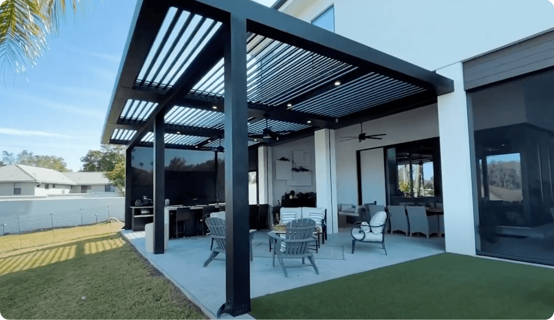 Black motorized pergola with ceiling fans over a patio, with a retractable screen on one side