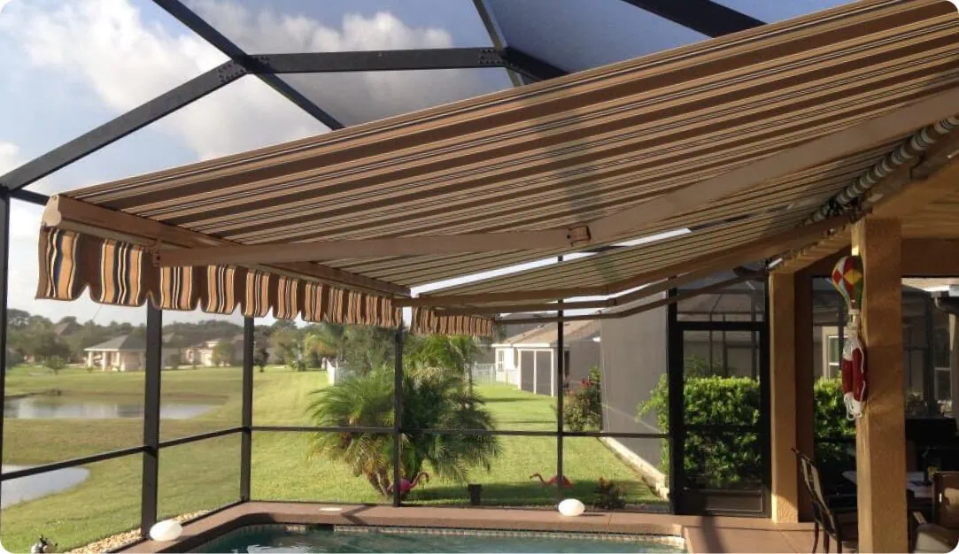Striped retractable awning extended inside a screened pool enclosure