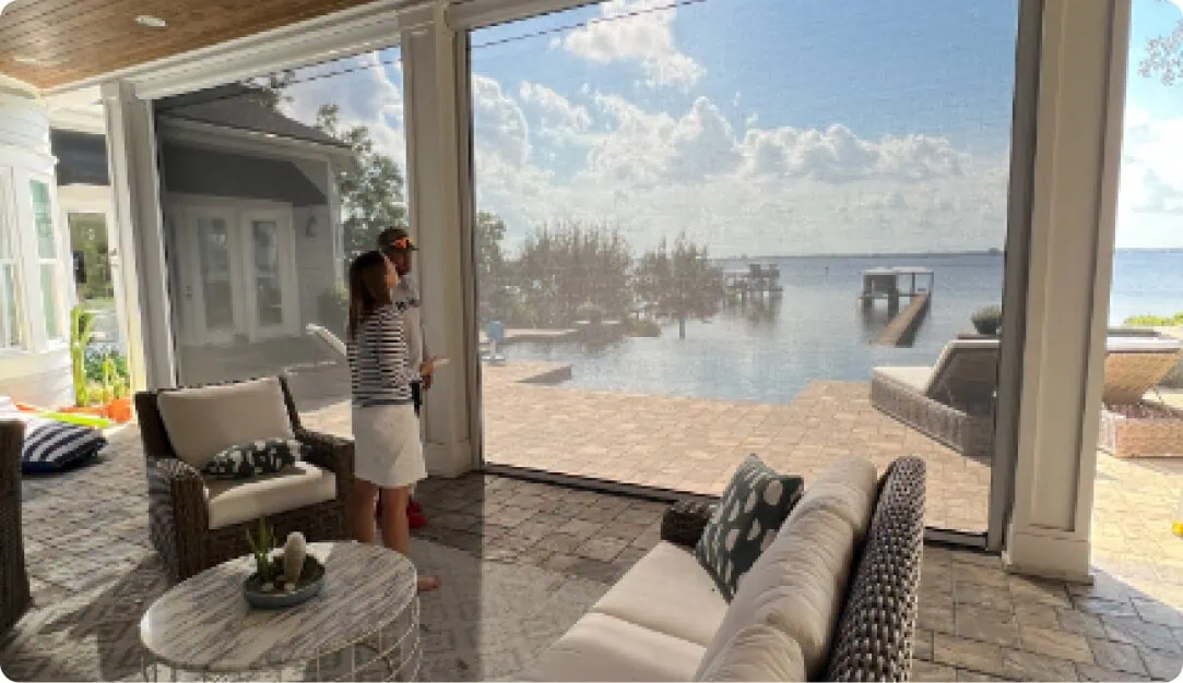 Homeowner inside a screened lanai looking out at the lake